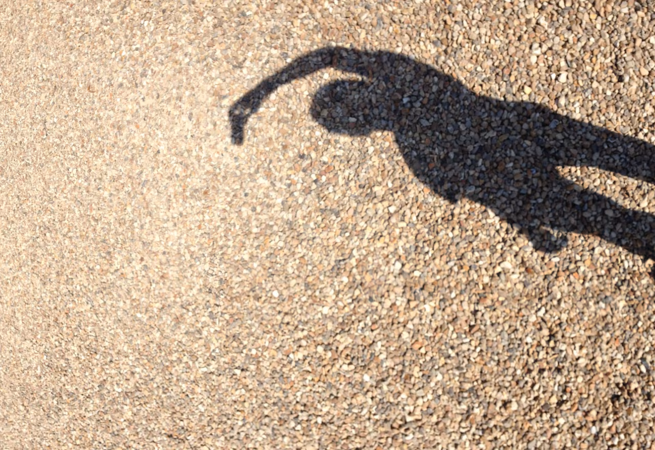 My own shadow on the gravel, camera raised – detail from a vertical panorama