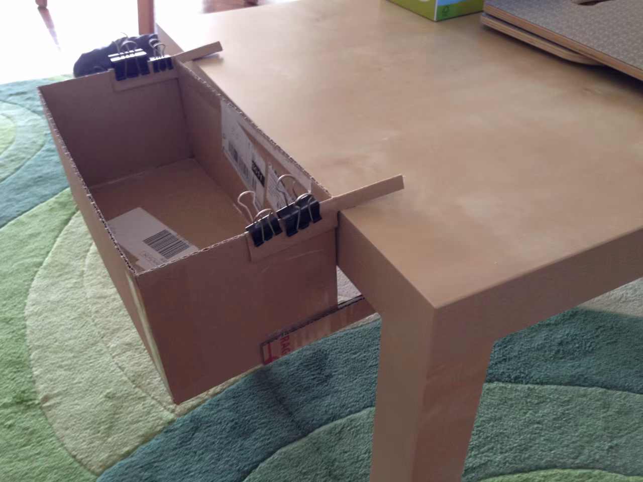 Cardboard prototype clipped to a table edge