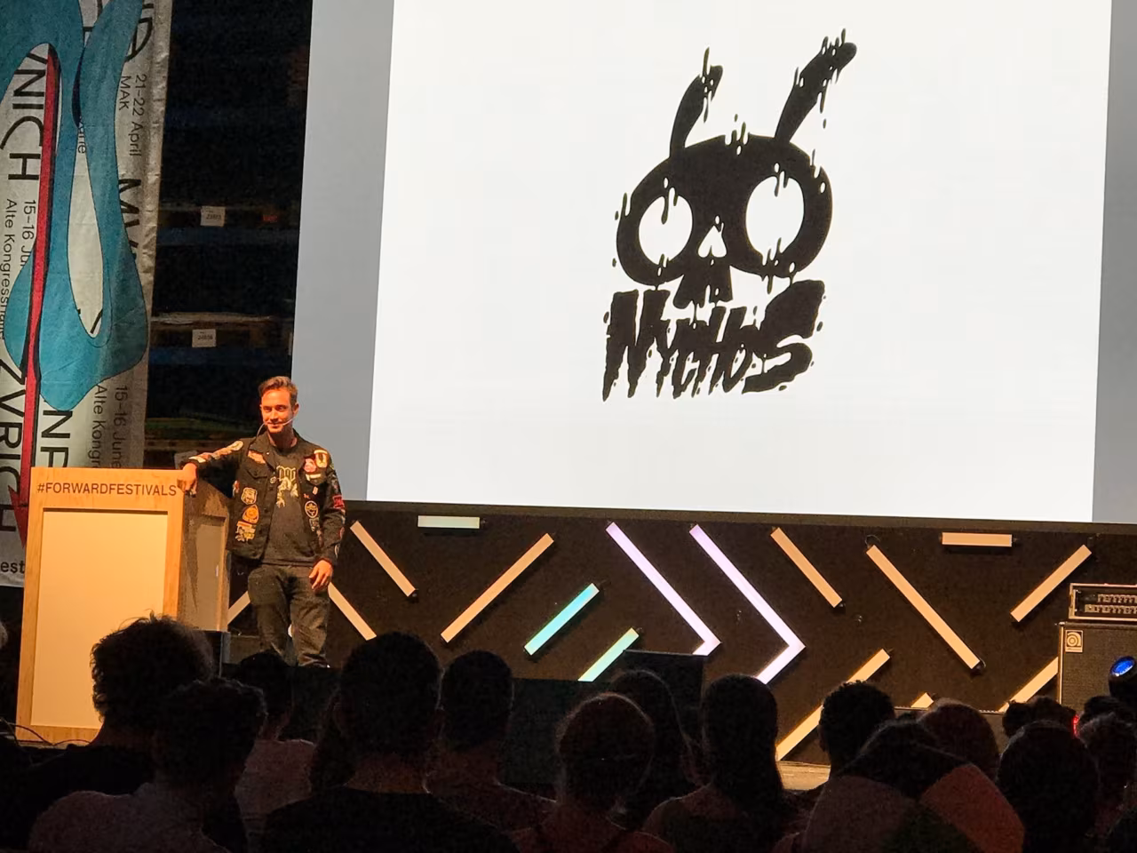 NYCHOS on stage at Forward Festival Zurich 2017, his logo on the screen behind him